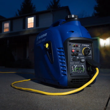 Westinghouse | iGen2500c portable inverter generator shown sitting in a driveway at night