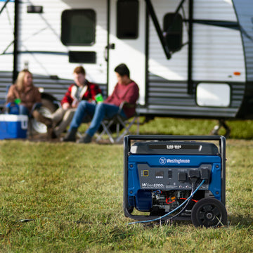 Westinghouse | WGen5300s portable generator is in the foreground. A camper with three people sitting outside of it are in the background.