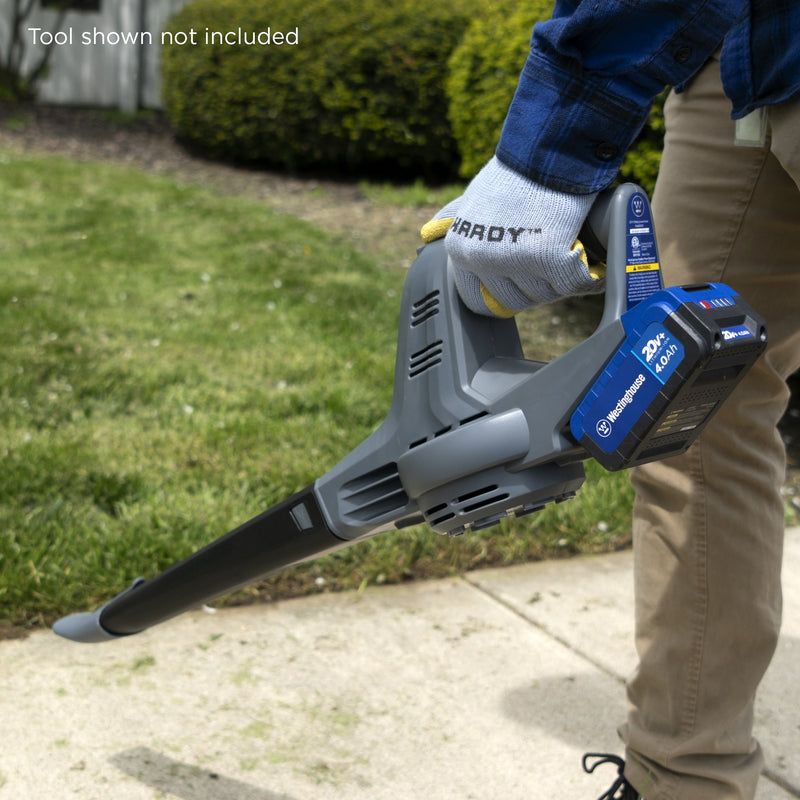 Person holding Westinghouse leaf blower with 4 Ah 20v battery in it grassy background