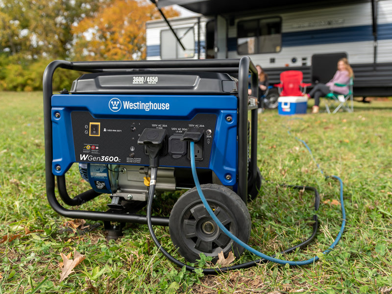 Westinghouse | WGen3600c portable generator sitting in grass with cords plugged into the household outlet and tt-30r outlet with people and a camper in the background