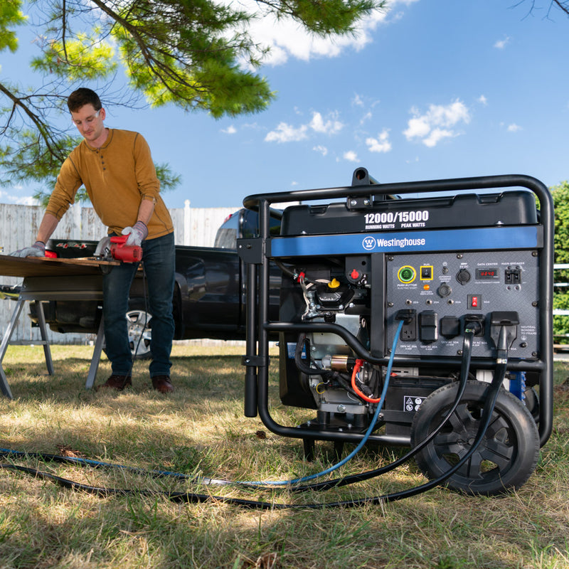 Westinghouse | WGen12000 portable generator sitting on grass with man working nearby.