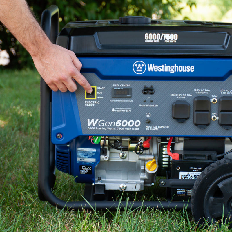 Westinghouse | WGen6000 portable generator sitting in grass while someone uses the control panel.